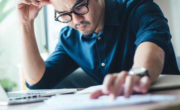 man staring intensely at his laptop monitor