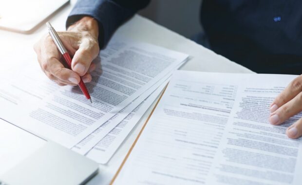 businessman reviewing document reports at office workplace with computer laptop